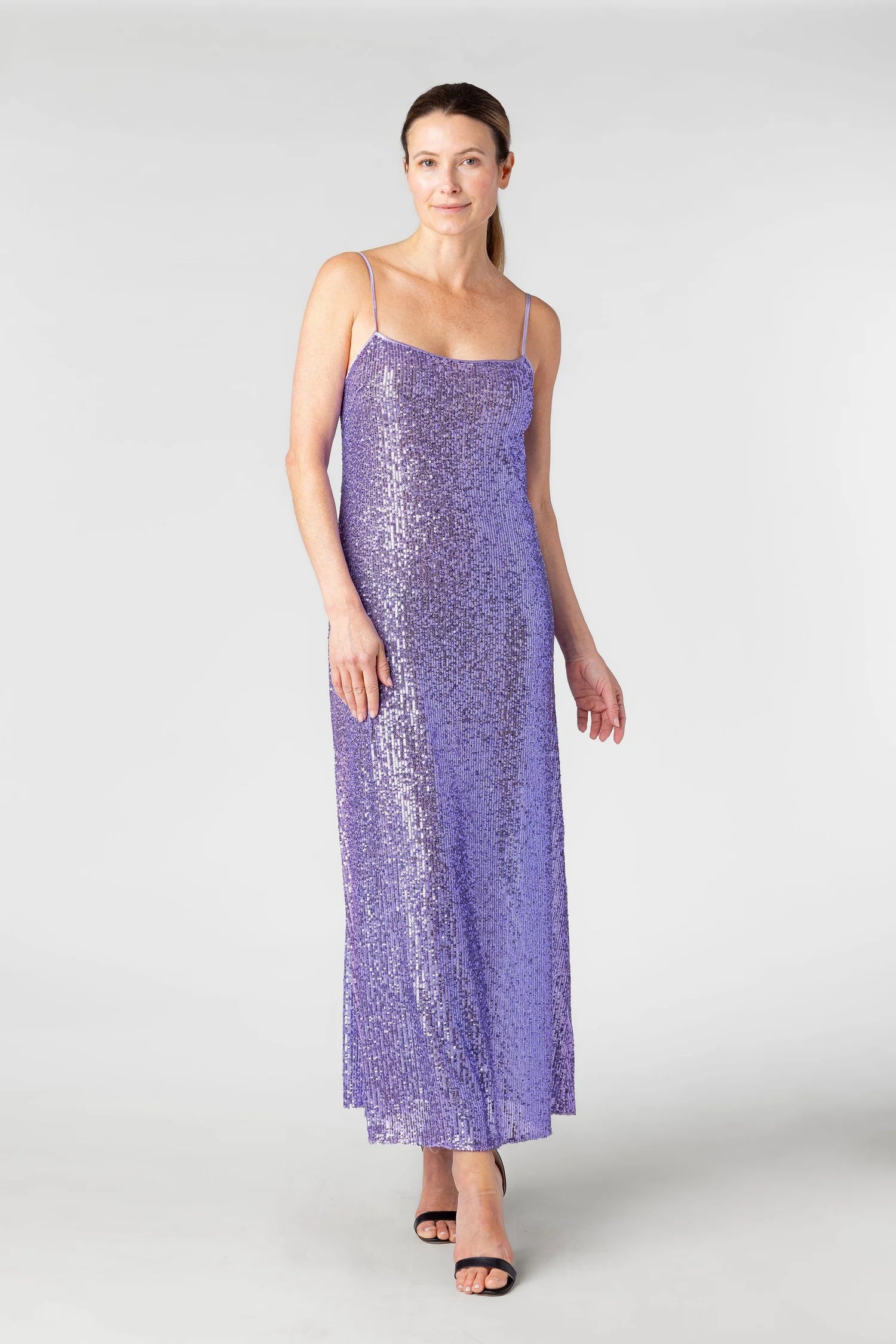 Woman wearing a purple sequin dress on a white background